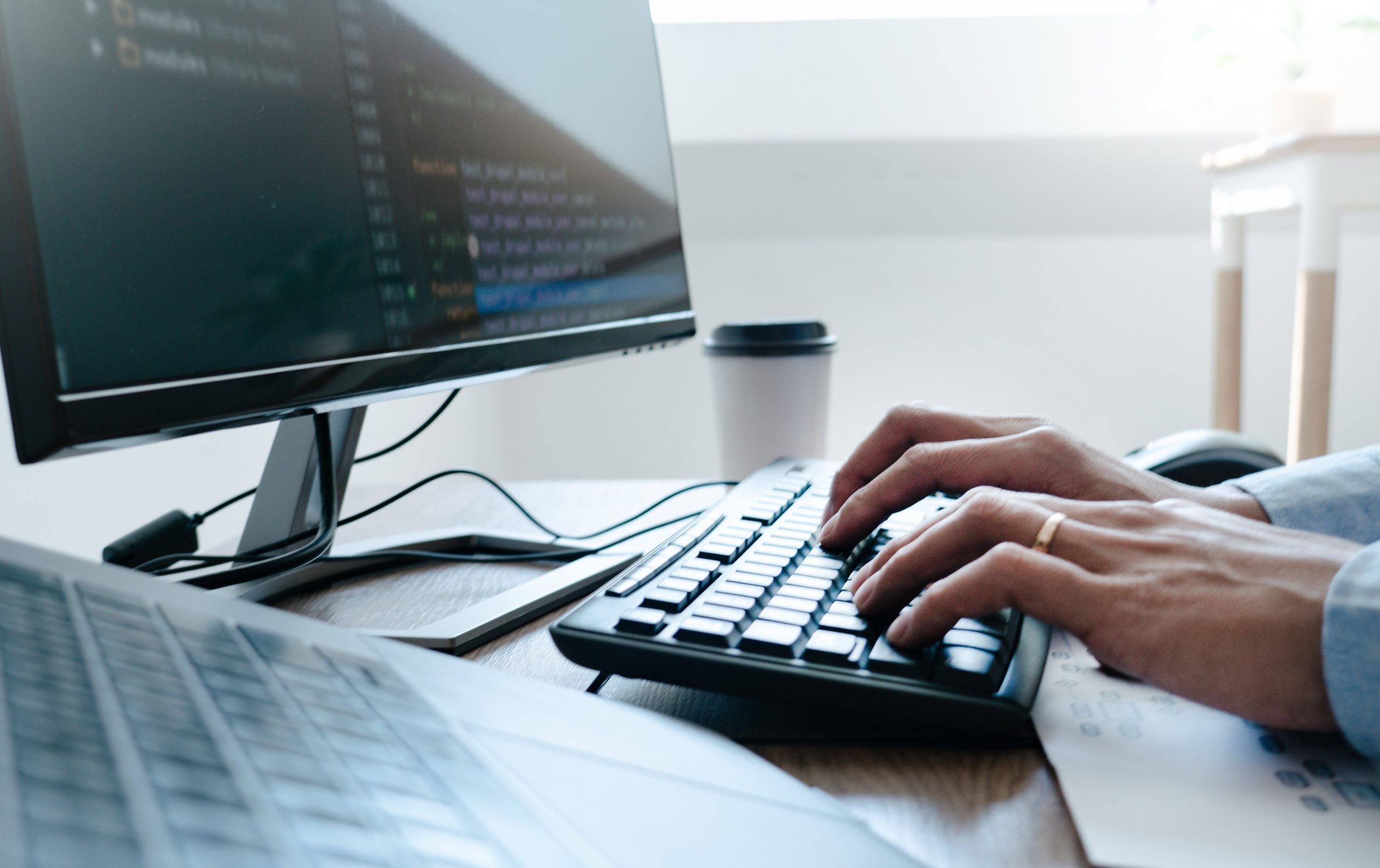 Programmer working On Computer In IT Office Typing Data Coding in software and checking code on computer screen.